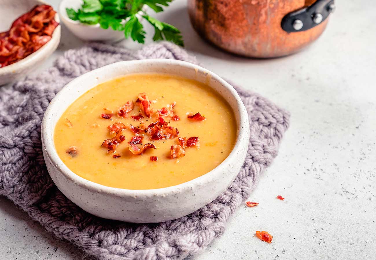 Crema de calabaza con lentejas rojas y beicon. Foto: Bigstock