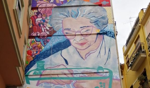 Una mural de una mujer mayor cosiendo rinde homenaje a todos los enfermos de alzhéimer en Valencia