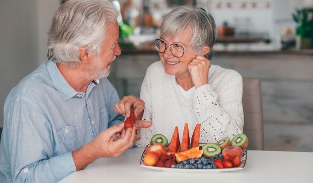 Dos personas comiendo fruta. Fuente: Bigstock