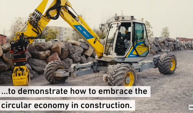 Un robot excavadora busca y diseña piedras para construir un muro de seis metros de altura