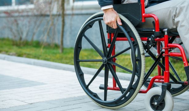Un hombre mayor de Aljaraque (Huelva) arregla un bordillo para poder pasar con su silla de ruedas (Bigstock)