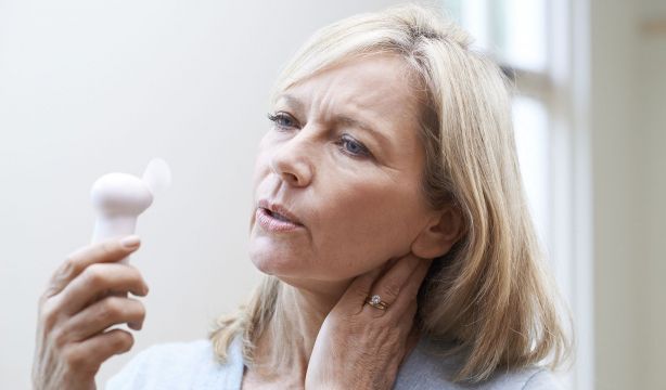 Una mujer con menopausia aliviando los sofocos. Fuente: Bigstock