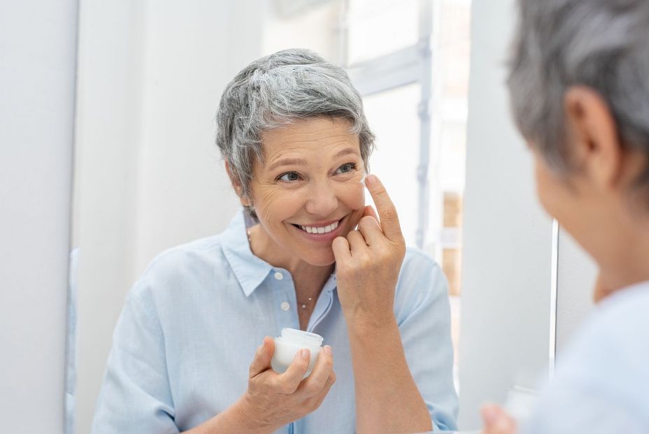 Una mujer madura usando productos para la piel. Bigstock.