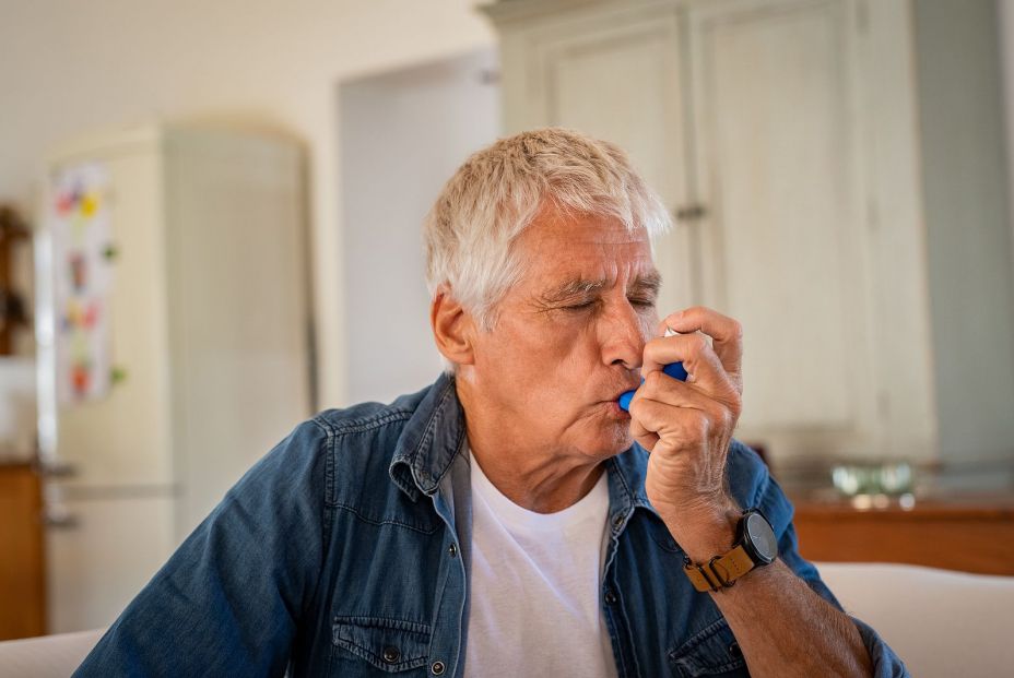 Un señor mayor usando un inhalador para el asma por culpa de la alergia al polen. (Bigstock)