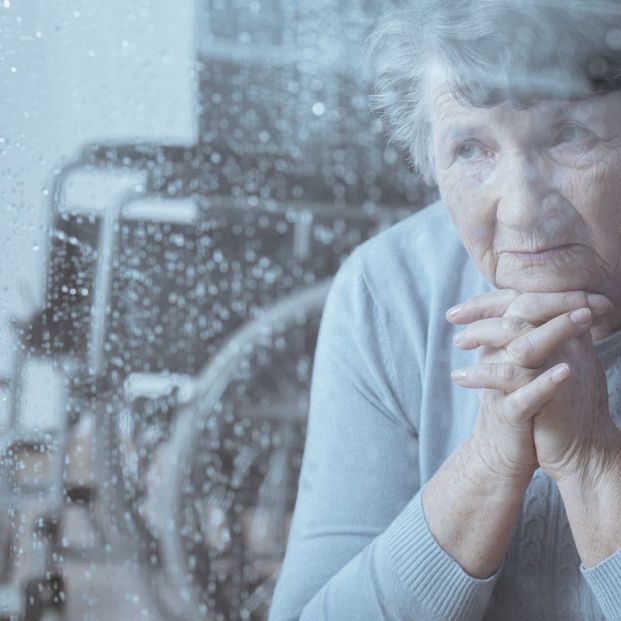 Una mujer con discapacidad mira por la ventana de su casa. (BIgstock)