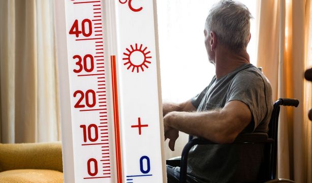 Persona mayor con tuermómetro que indica calor y temperaturas altas