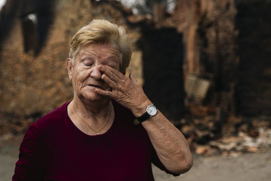 Una vecina de Castrocalbón, junto a una vivienda que ha sido destruida por los incendios, a 20 de agosto de 2025, en Castrocalbón, León, Castilla y León