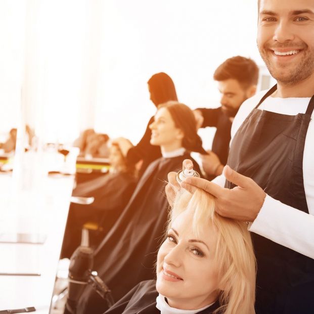 Mujer con estilista retocándole el pelo
