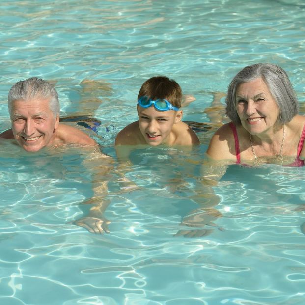 Abuelos y nietos hacen deporte en la piscina Abuelos y nietos hacen deporte en la piscina