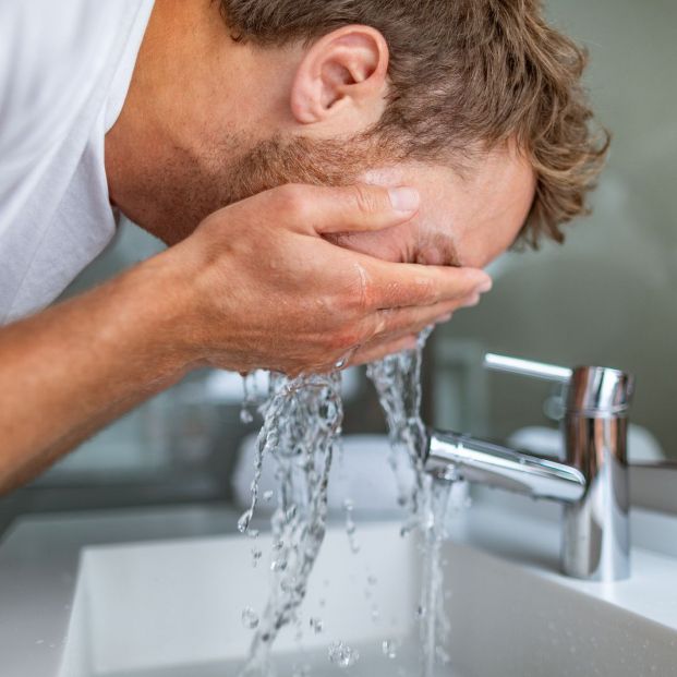 bigstock Face wash man in bathroom wash 330758146