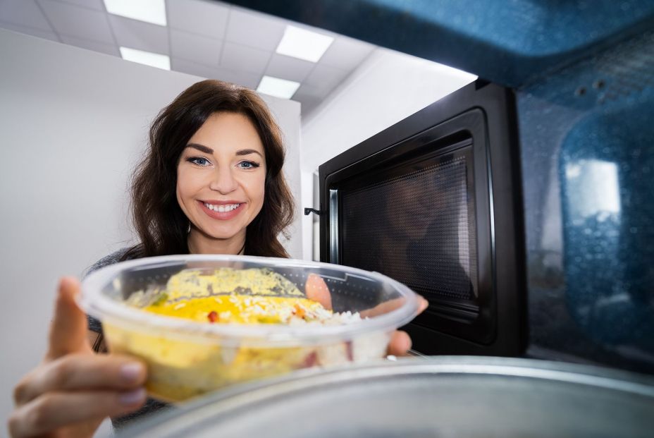 bigstock Young Woman Heating Fried Food 370969450
