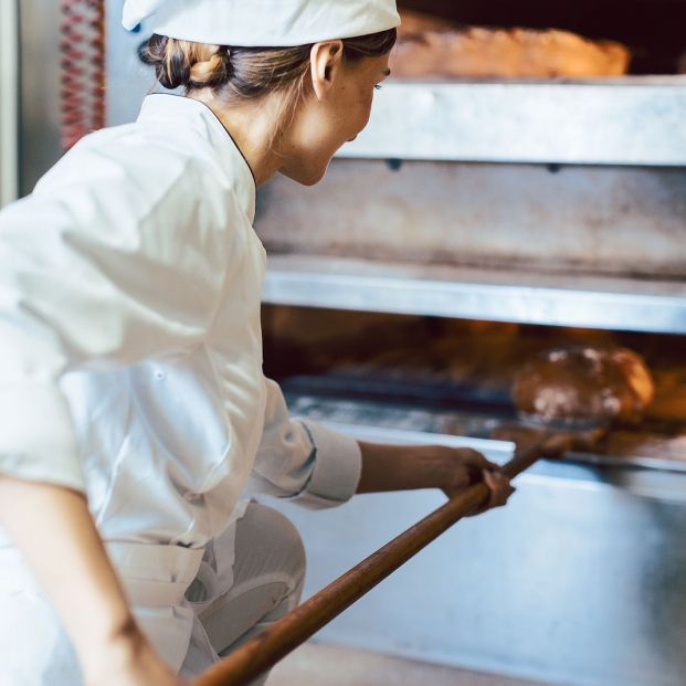 bigstock Baker putting bread in the bak 387217516