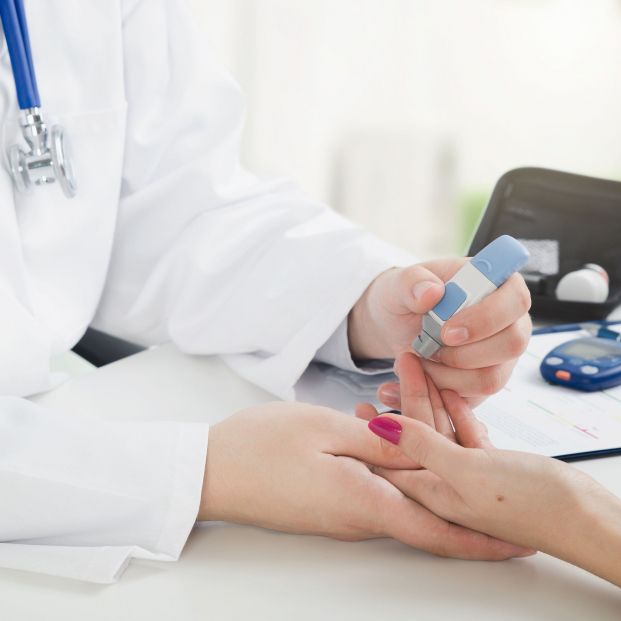 Doctora haciendo la prueba de diabetes a una paciente Doctora haciendo la prueba de diabetes a una paciente