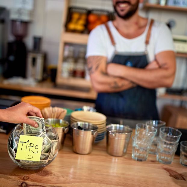 bigstock Woman is putting one dollar bi 336782857