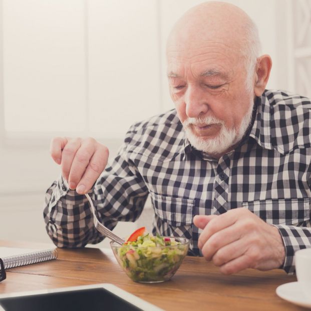 Hombre comiendo una ensalada Hombre comiendo una ensalada
