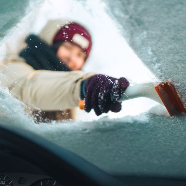 mujer quitando hielo parabrisas